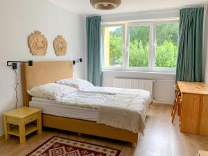 a bedroom with a bed with green curtains and a window at Między górami. Apartament w Cisnej in Cisna