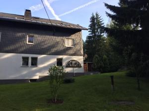 a house with a green yard next to a building at Ferienwohnung Eulennest in Dippoldiswalde
