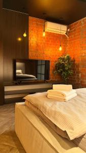 een slaapkamer met een bed en een bakstenen muur bij Люкс в стиле LOFT in Pavlodar