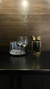 twee glazen zittend op een tafel met een dienblad bij Люкс в стиле LOFT in Pavlodar