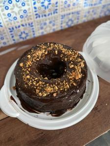 a chocolate doughnut on a plate on a table at POUSADA MAORI Boiçucanga in Boicucanga