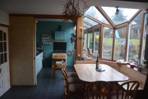 una cocina y comedor con una mesa en una casa en B&B La Source Houffalize en Houffalize