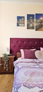 ein violettes Bett mit einem lila Kopfteil in einem Schlafzimmer in der Unterkunft Best Two Room Apartment in Mukatschewo