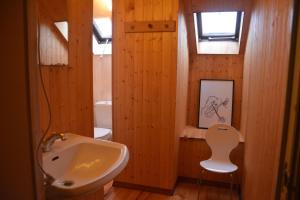 a bathroom with a sink and a chair in it at B&B La Source Houffalize in Houffalize