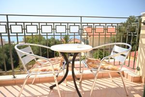2 Stühle und ein Tisch auf dem Balkon in der Unterkunft liocharis villas in Lourdata