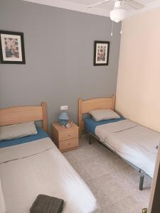 um quarto com 2 camas e uma mesa de cabeceira com um candeeiro em Appartement avec piscine à Algorfa em Algorfa