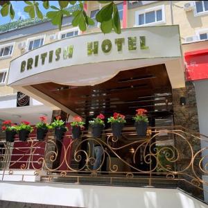 a hotel sign with potted plants on a balcony at British Hotel Pogradec in Pogradec