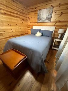 a bedroom with a bed in a log cabin at Hillside Hideaway in Longview