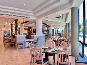 un restaurant avec des tables et des chaises en bois ainsi que des fenêtres dans l'établissement Hotel Florencia by Marho, à Querétaro