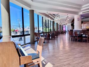 un comedor con mesas, sillas y ventanas en Hotel Florencia by Marho, en Querétaro