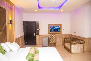 a hotel room with a bed and a tv at Emperor Melanie Hotels in Awka