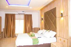 Akwa的住宿－Emperor Melanie Hotels，卧室设有一张白色大床和一扇窗户。