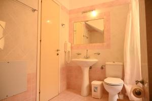 y baño con aseo, lavabo y ducha. en liocharis villas en Lourdhata