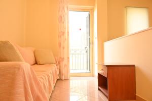 ein Schlafzimmer mit einem Bett, einer Kommode und einem Fenster in der Unterkunft liocharis villas in Lourdata
