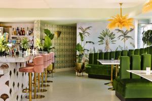 a restaurant with green furniture and plants on the walls at Sonder The Beacon in Los Angeles