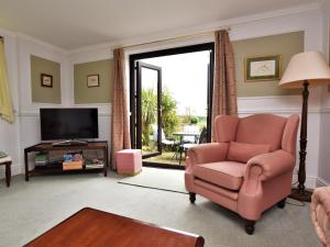 a living room with a pink chair and a television at 2 Bed in Holmesfield PK783 in Dronfield