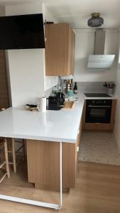 a kitchen with a white counter top and wooden cabinets at Captivating apartment with all amenities in Bordeaux