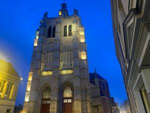 un grand bâtiment avec une tour d'horloge la nuit dans l'établissement Appartement 3 - Hyper centre - 1 à 4 personnes, à Douai