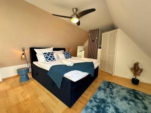 a bedroom with a bed with a ceiling fan at ٤Neu٤Fantastischer Meerblick-Stylish-King Bed-PP in Scharbeutz