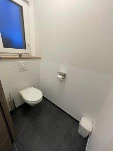a bathroom with a toilet and a tv on the wall at L'Orée des Champs in Lérouville