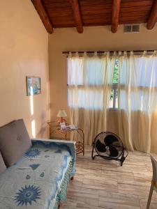 ein Schlafzimmer mit einem Bett und einem großen Fenster in der Unterkunft LOS CLAVELES in Federación