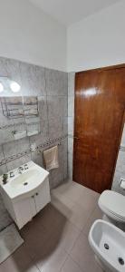 ein Bad mit einem Waschbecken, einem WC und einer Tür in der Unterkunft Patuli House - Casa alquiler temporario Córdoba in Cordoba + 16 Fotos