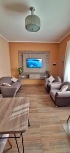 uma sala de estar com sofás e uma televisão de ecrã plano em Patuli House - Casa alquiler temporario Córdoba em Córdoba
