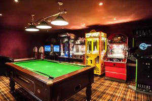 a room with a pool table and arcade machines at Moffat Manor Holiday Resort in Beattock