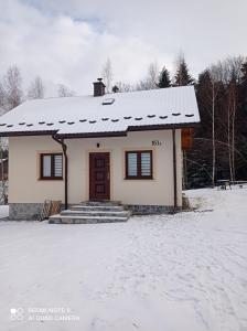 a small house with a snow covered roof at DOMEK ANNY in Ropica Dolna +14 photos