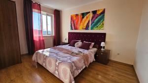 ein Schlafzimmer mit einem Bett und einem Wandgemälde in der Unterkunft Best Two Room Apartment in Mukatschewo