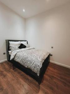 a bedroom with a bed and a wooden floor at CentralGem Retreat 01 in Redditch