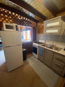 a kitchen with a white refrigerator and a sink at Peaceful Oasis near Combate Beach in Cabo Rojo