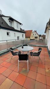 een patio met een tafel en stoelen op een dak bij Fewo Reutlingen Heinestrasse in Reutlingen