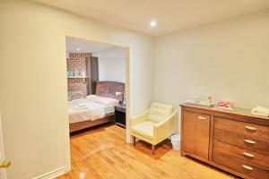um quarto com uma cama, uma cadeira e um espelho em Beautiful room with private powder room em Vaughan