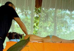 Ein Mann bereitet eine Frau auf einem Bett vor. in der Unterkunft Amazona Lodge in Leticia