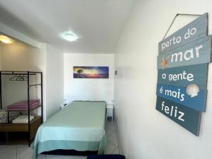 a room with a bed and a sign on the wall at Tony Gandra in Florianópolis