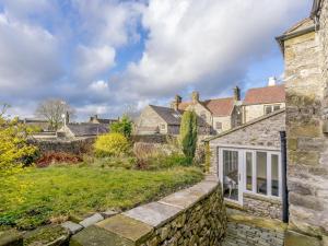 a cottage in a village with a stone wall at 3 Bed in Hartington 77739 in Hartington