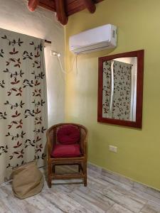 a room with a red chair and a fan at LOS CLAVELES in Federación