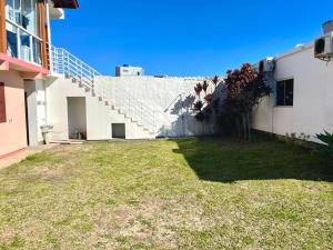 a white building with a staircase on the side of it at Tony Gandra in Florianópolis