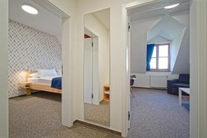 a bedroom with a bed and a room with a mirror at HOTEL Hraniční zámeček in Hlohovec