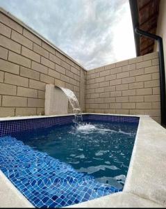 une piscine avec une fontaine à eau dans l'établissement Casa de cond com piscina e churrasqueira particular, à Itanhaém