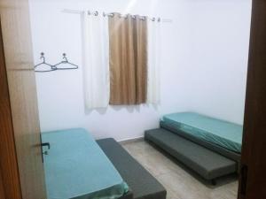 une chambre avec deux lits et une fenêtre dans l'établissement Casa de cond com piscina e churrasqueira particular, à Itanhaém 31 autres photos