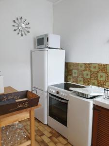 a kitchen with a white stove and a refrigerator at Appartement au cœur du Berry in Lignières