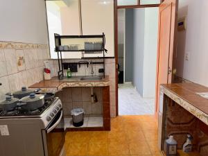a kitchen with a stove and a sink at Morada Apart in Tacna