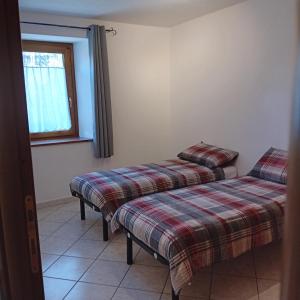 twee bedden in een kamer met een raam bij Maison Clair Vda Gressan n 0094 in Aosta