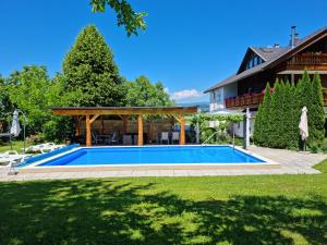 a swimming pool in a yard next to a house at Apartments Presslauer - Mori in Sankt Kanzian