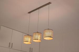 a group of three lights hanging from a ceiling at Urban Oasis Apartments at Hidas in Windhoek