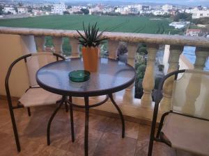 een tafel met twee stoelen en een plant op een balkon bij Elenas Home in Limassol