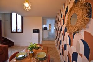 a dining room with a table and a kitchen at Tour Pleyel - Duplex Lumineux in Saint-Denis