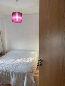 a bedroom with a bed and a pink light at At Moustapha in San Juan de Aznalfarache